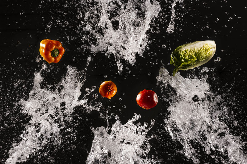 Flying fresh vegetables in splashes of water Imagen De Lavado De Vegetales Como Lelchuga, Pimiento Y Jitomate. Desinfección De Vegetales Con Ozono